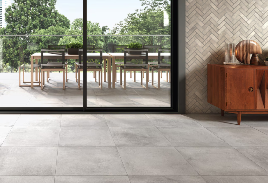 light grey floor tile in a kitchen that leads out to a back patio through sliding doors